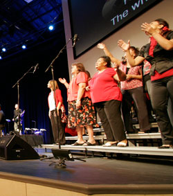 Church choir on stage with large diaphragm microphones picking up their sound.