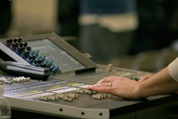 House of worship sound tech with his hands on a Yamaha digital audio mixing console